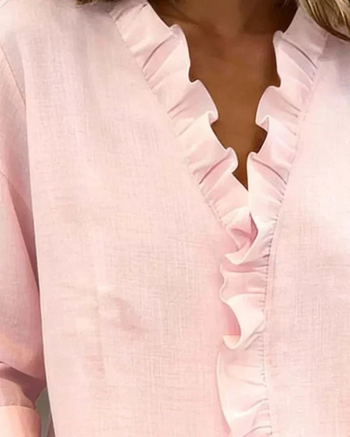 Blusa Chiara de Alessia Madrid con cuello en V y volantes delicados, muestra detalles de la tela y diseño elegante.
