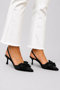 Zapatos de tacón con lazo de la marca Alessia Madrid, modelo Aurora, en color negro, con diseño elegante y detalles en la parte superior.