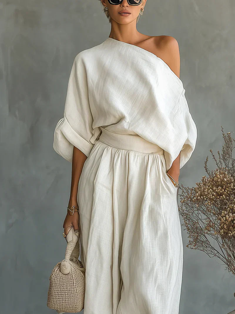 Conjunto de 2 piezas con hombros descubiertos de Alessia Madrid, blusa y pantalones en color blanco, estilo elegante y moderno.