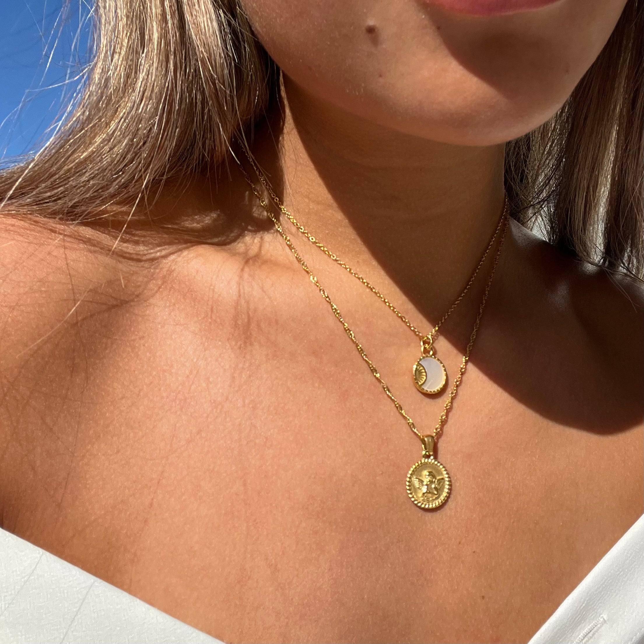 Collar de ángel de la marca Alessia Madrid, con delicado diseño de ángel en plata brillante sobre fondo neutro.